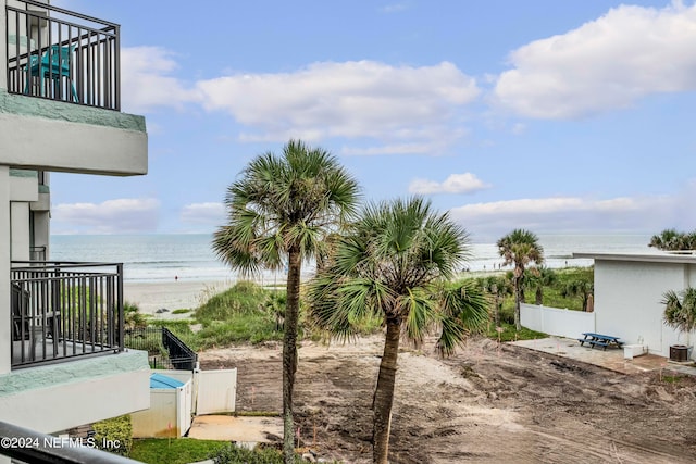 view of yard with a view of the beach, a water view, and a balcony