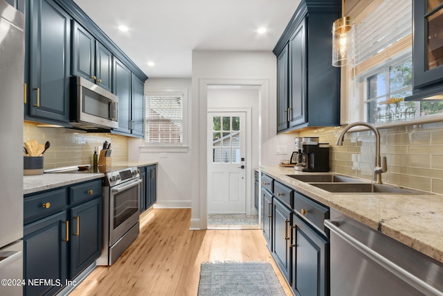 kitchen featuring a healthy amount of sunlight, light hardwood / wood-style floors, sink, and stainless steel appliances