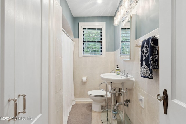 bathroom featuring tile walls, walk in shower, and toilet