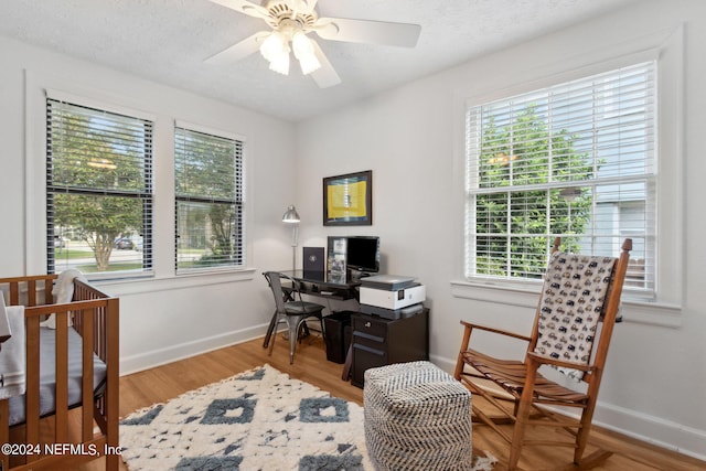 office area featuring a textured ceiling, light hardwood / wood-style floors, and ceiling fan