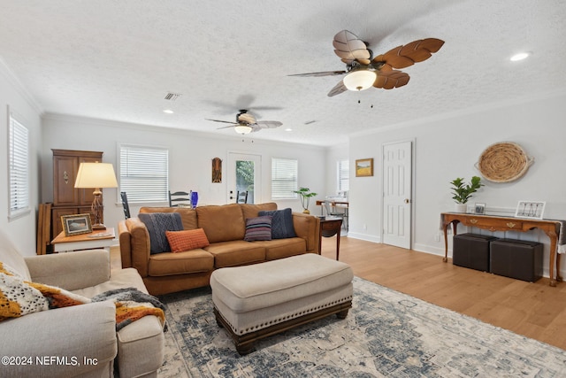 living room with a textured ceiling, ornamental molding, hardwood / wood-style floors, and ceiling fan