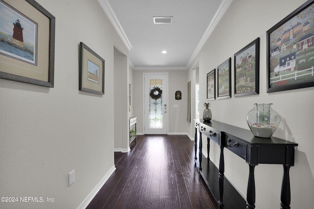 foyer featuring dark wood-type flooring, a textured ceiling, and crown molding