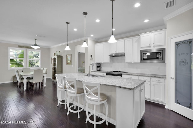 kitchen with appliances with stainless steel finishes, white cabinets, decorative light fixtures, and sink