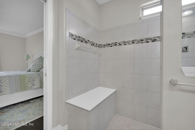 bathroom featuring tiled shower and ornamental molding