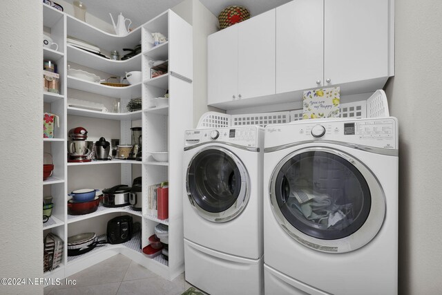 laundry area featuring cabinets, light tile patterned floors, and independent washer and dryer