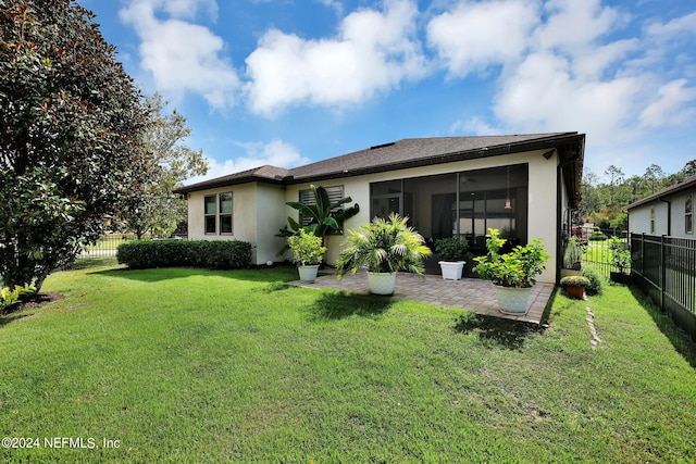 rear view of house with a sunroom and a yard