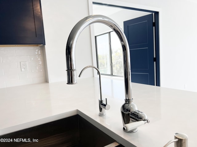 interior details featuring decorative backsplash, dark brown cabinetry, and sink