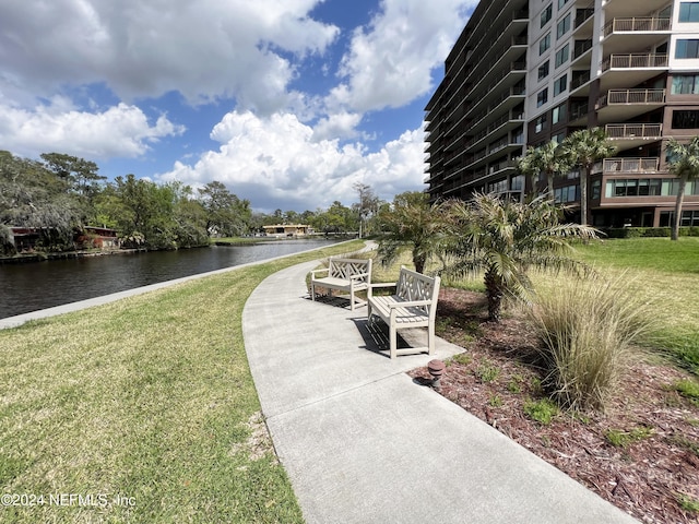 view of home's community with a lawn and a water view