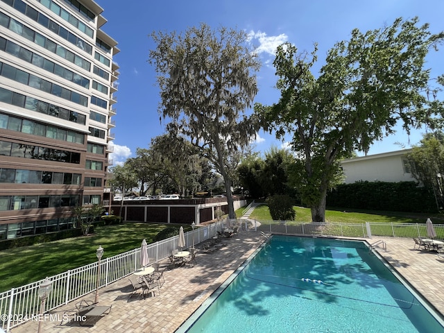 view of swimming pool with a yard and a patio area