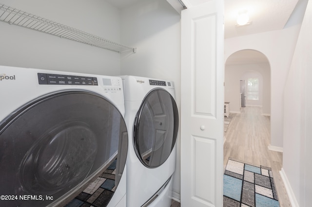 laundry room with hardwood / wood-style floors and independent washer and dryer