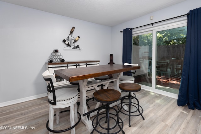 dining room with light hardwood / wood-style flooring and a textured ceiling