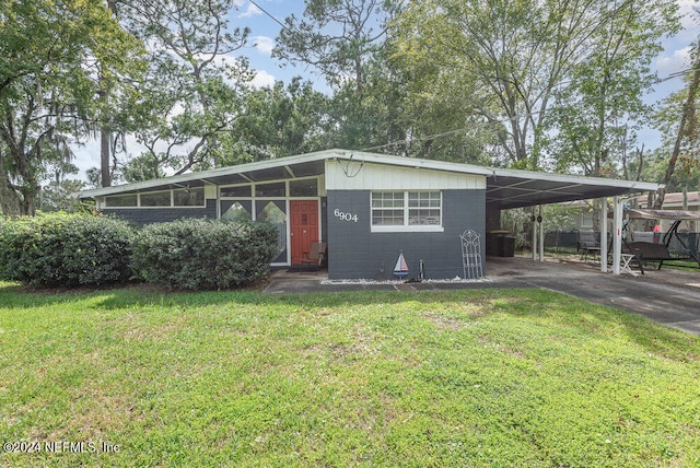 view of front of house with a front yard and a carport