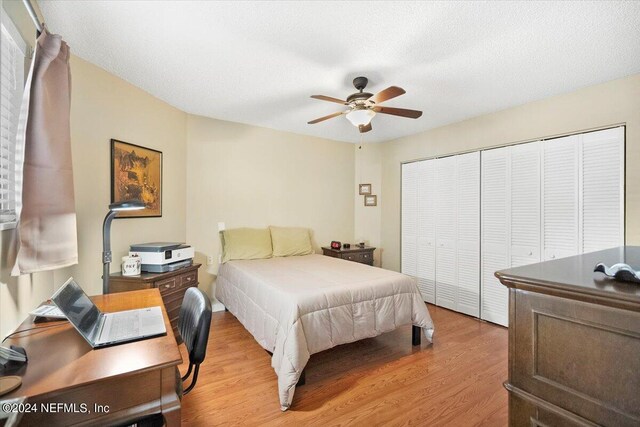 bedroom with a textured ceiling, ceiling fan, light hardwood / wood-style flooring, and a closet