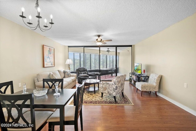 dining area featuring ceiling fan with notable chandelier, floor to ceiling windows, a textured ceiling, and dark hardwood / wood-style flooring