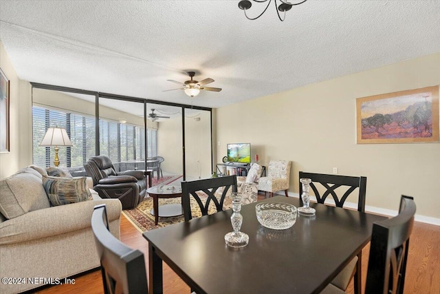 dining area with ceiling fan, a textured ceiling, and wood-type flooring