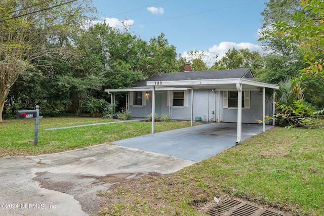 rear view of property featuring a lawn and a carport