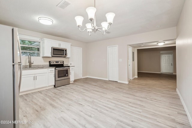 kitchen featuring light hardwood / wood-style flooring, white cabinets, stainless steel appliances, and hanging light fixtures