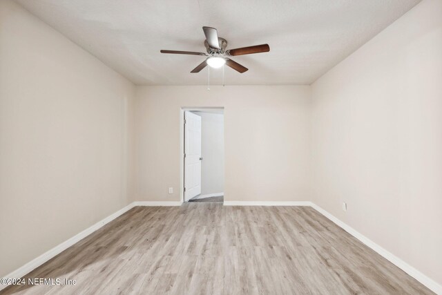 empty room with light hardwood / wood-style flooring and ceiling fan