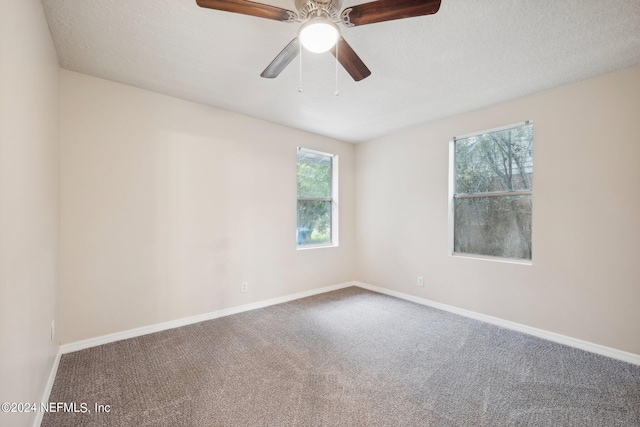 empty room with ceiling fan, carpet, and a textured ceiling