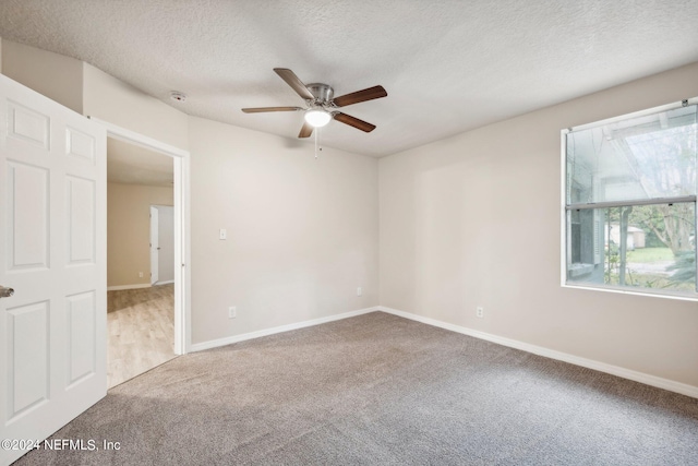 spare room featuring carpet, a textured ceiling, and ceiling fan