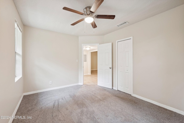 spare room with light colored carpet and ceiling fan