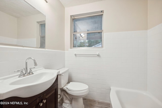 full bathroom featuring hardwood / wood-style flooring, toilet, vanity, tile walls, and a textured ceiling