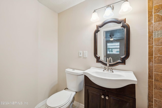 bathroom with toilet, a textured ceiling, and vanity