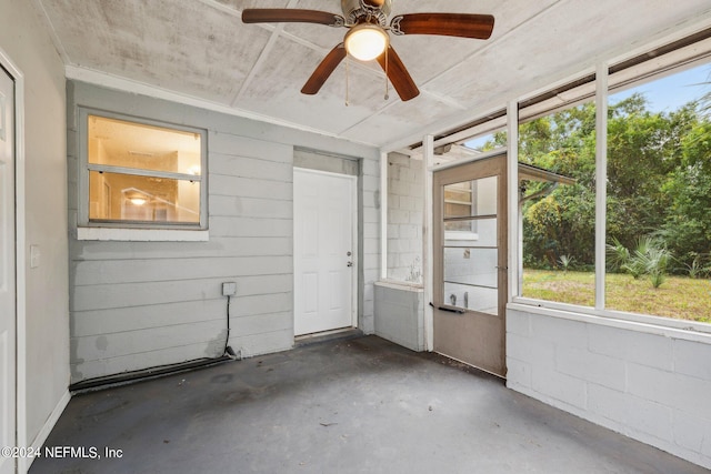 unfurnished sunroom featuring ceiling fan