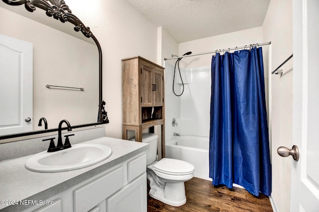 full bathroom featuring wood-type flooring, a textured ceiling, toilet, shower / tub combo with curtain, and vanity