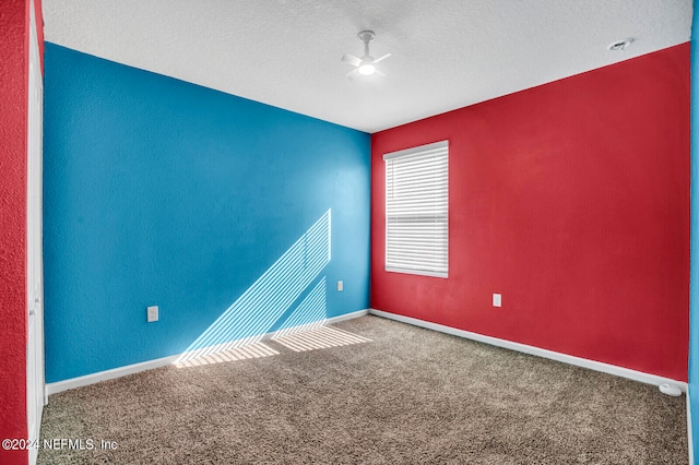 carpeted empty room with a textured ceiling