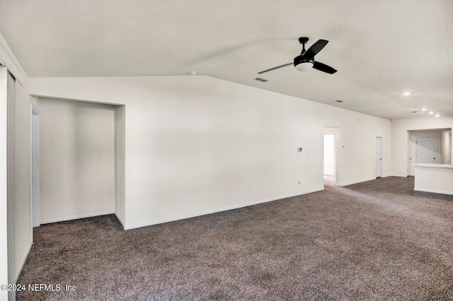 unfurnished living room featuring a textured ceiling, ceiling fan, dark carpet, and vaulted ceiling