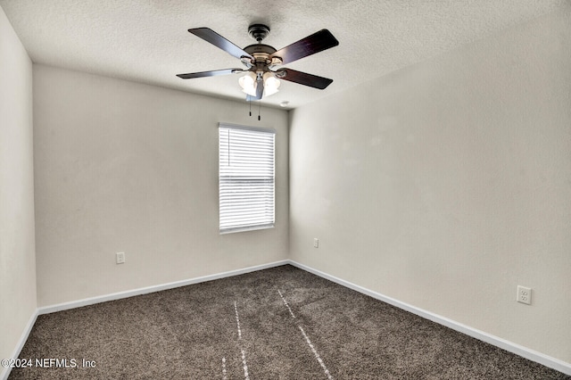 unfurnished room with ceiling fan, dark carpet, and a textured ceiling