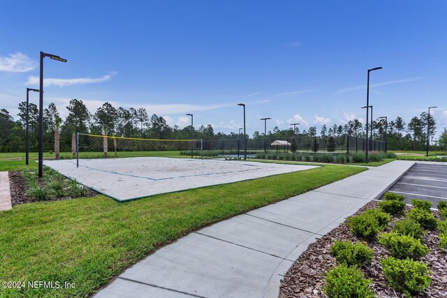 view of home's community featuring volleyball court and a lawn