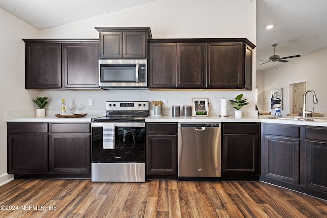 kitchen with appliances with stainless steel finishes, dark hardwood / wood-style flooring, ceiling fan, dark brown cabinetry, and sink