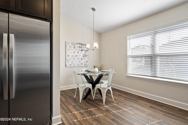 dining area featuring vaulted ceiling, dark hardwood / wood-style flooring, and a chandelier