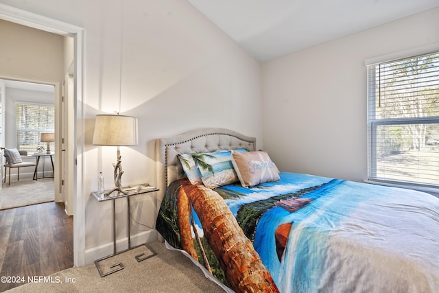 bedroom with lofted ceiling and dark hardwood / wood-style flooring