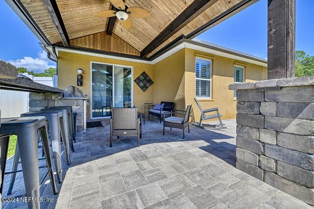 view of patio featuring area for grilling, ceiling fan, and an outdoor kitchen