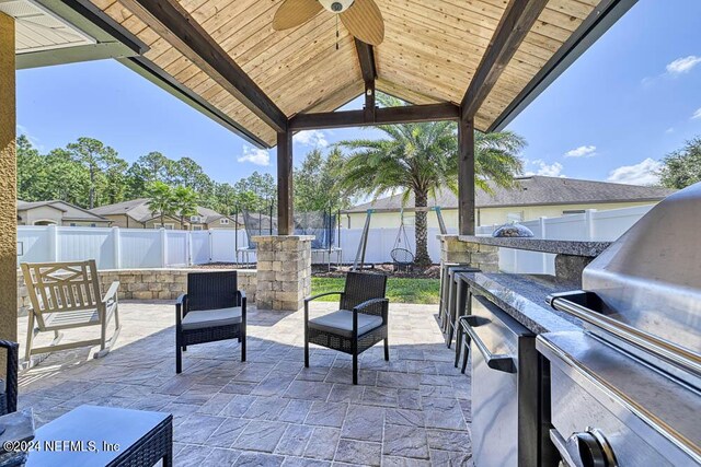 view of patio / terrace featuring ceiling fan, a gazebo, and exterior kitchen