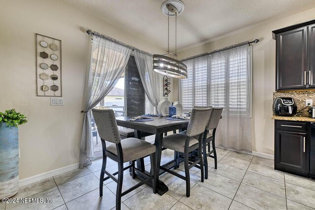 dining room with an inviting chandelier, a textured ceiling, and light tile patterned flooring