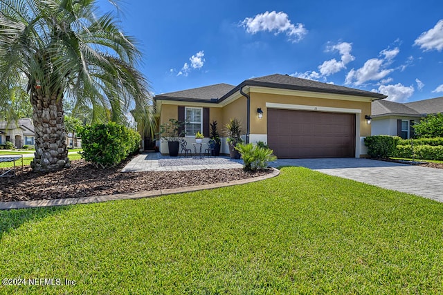 view of front of property with a garage and a front lawn