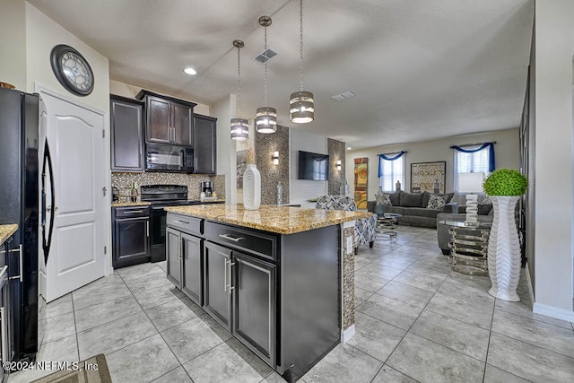 kitchen featuring decorative backsplash, light stone counters, black appliances, a center island, and decorative light fixtures