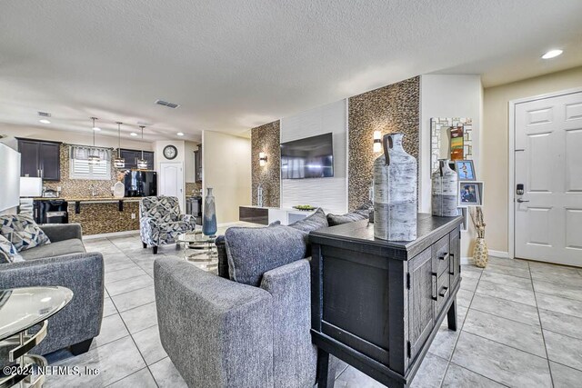 tiled living room featuring a textured ceiling