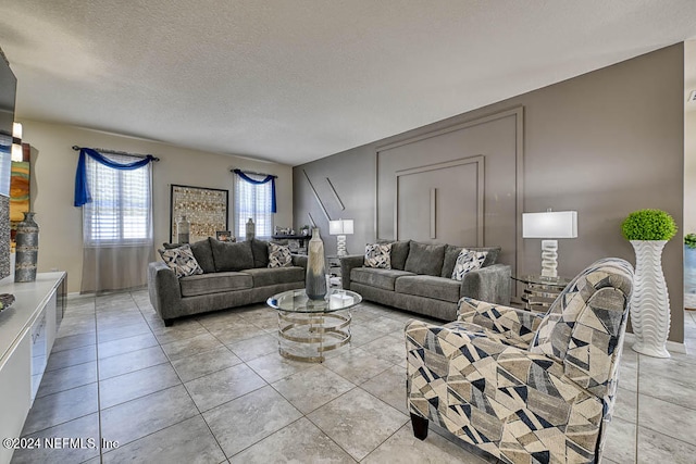 living room featuring a textured ceiling and light tile patterned floors