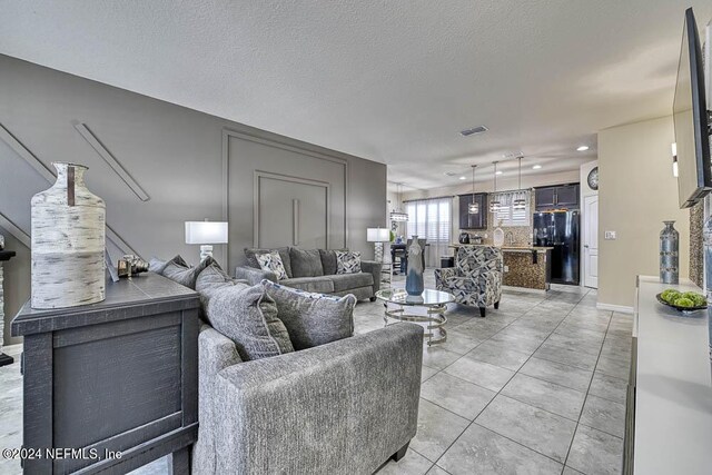 tiled living room featuring a textured ceiling