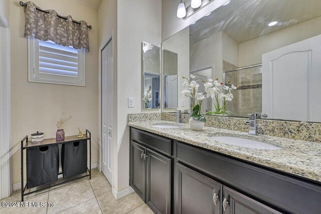 bathroom with tile patterned floors, walk in shower, and vanity