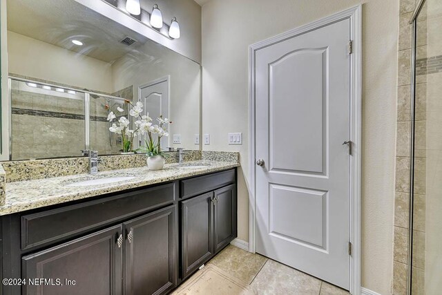 bathroom featuring vanity, tile patterned floors, and a shower with shower door