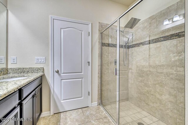 bathroom featuring walk in shower, tile patterned flooring, and vanity