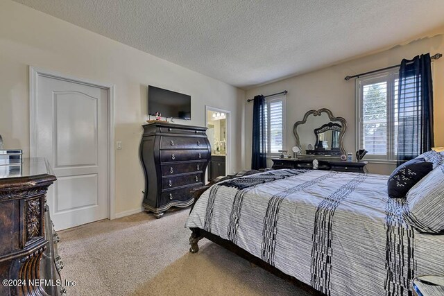 carpeted bedroom featuring a textured ceiling and multiple windows