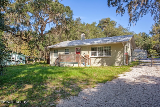 ranch-style house with a wooden deck and a front lawn