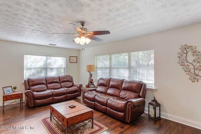 living room with dark wood-type flooring, a textured ceiling, and ceiling fan